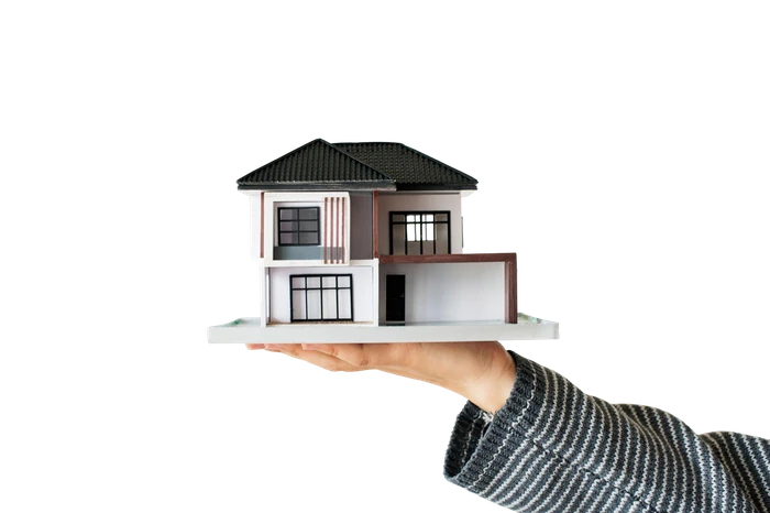 A hand holding a model house